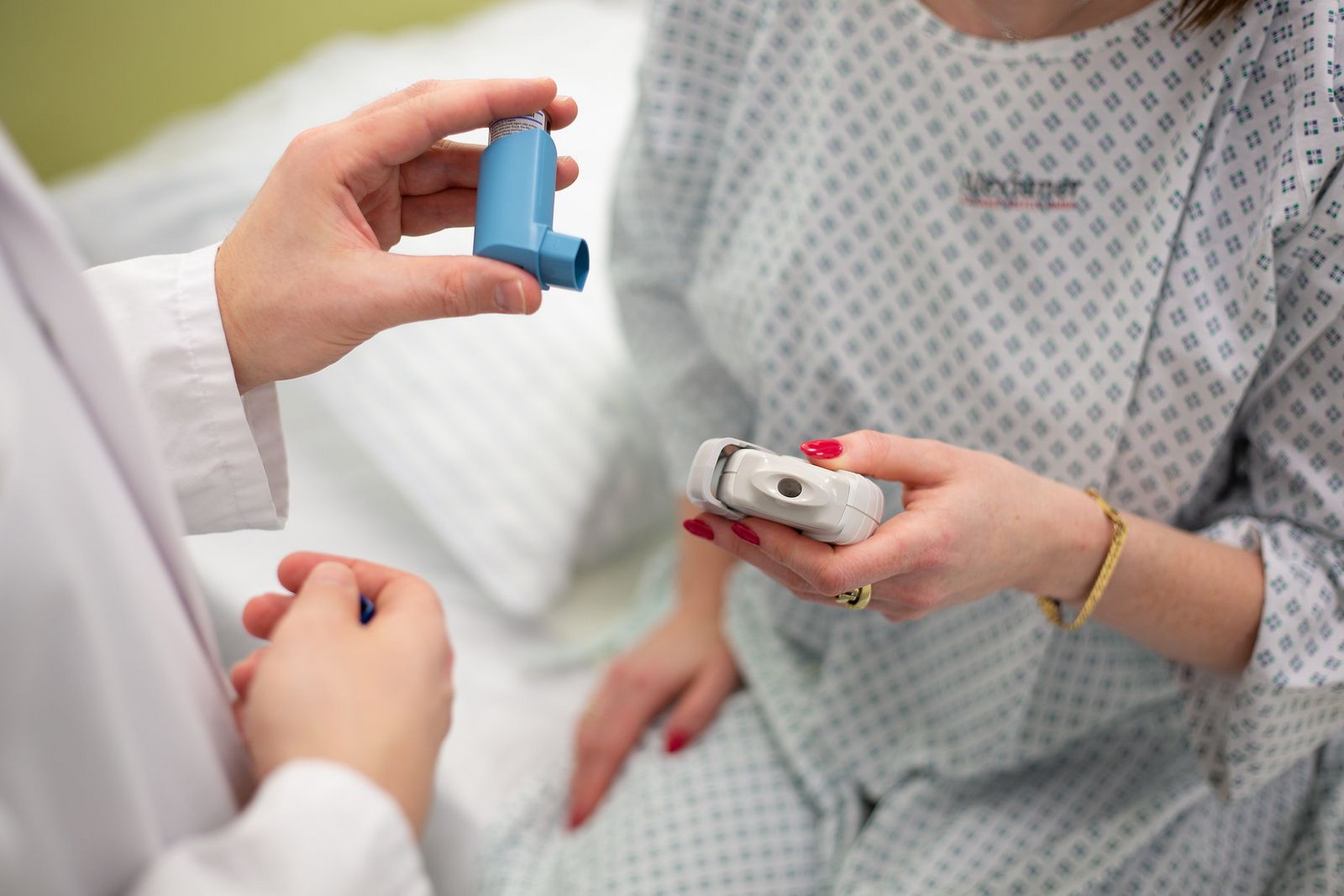 Apotheker erklärt Patientin die richtige Anwendung eines Inhalators