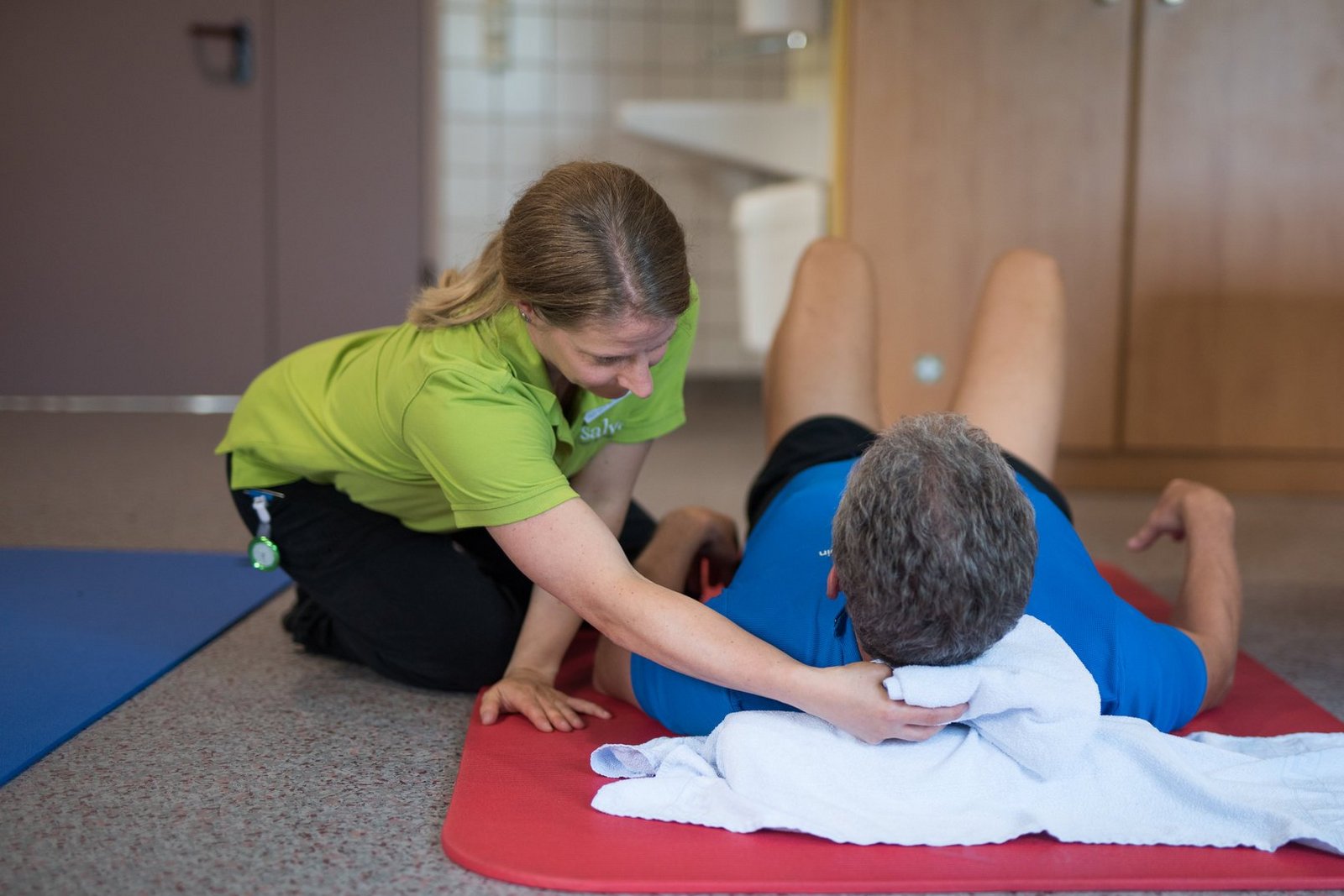 Physiotherapeutin unterstützt Patient bei der Rehabilitationstherapie Physiotherapeutin unterstützt Patient bei der Rehabilitationstherapie
