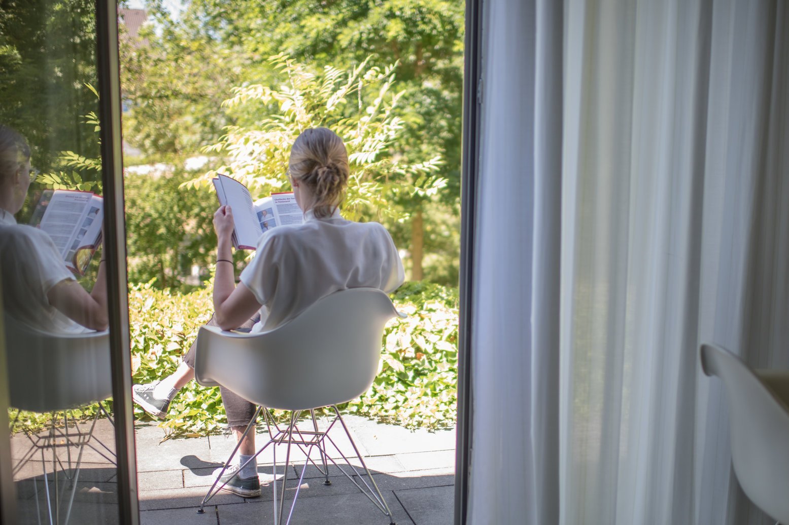 Patientin entspannt mit Blick in den Garten Patientin entspannt mit Blick in den Garten