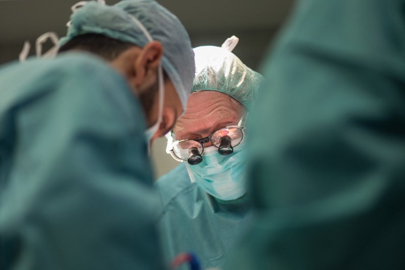 Prof. Dr. Dr. Bernd Luther blickt mit Lupenbrille in die feinen Strukturen eines Beingefäßes Prof. Dr. Dr. Bernd Luther blickt mit Lupenbrille in die feinen Strukturen eines Beingefäßes