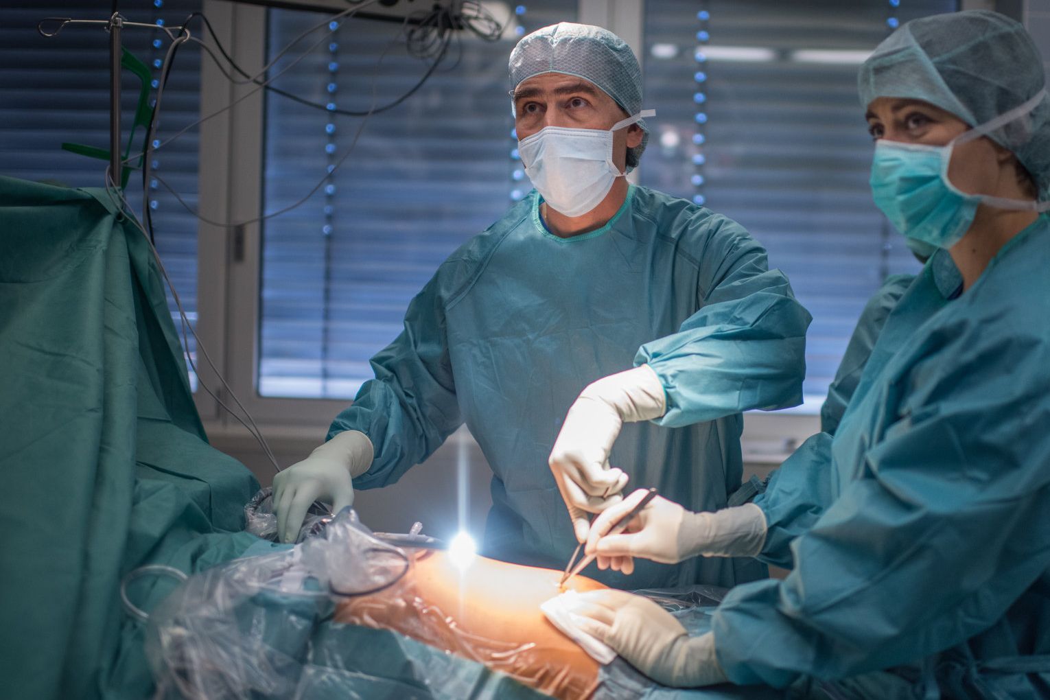 Ärztin und Arzt im Operationssaal bei Gallenoperation mit miminal-invasiver Operationstechnik, das bedeutet operieren über kleinste Hautschnitte in den Körper