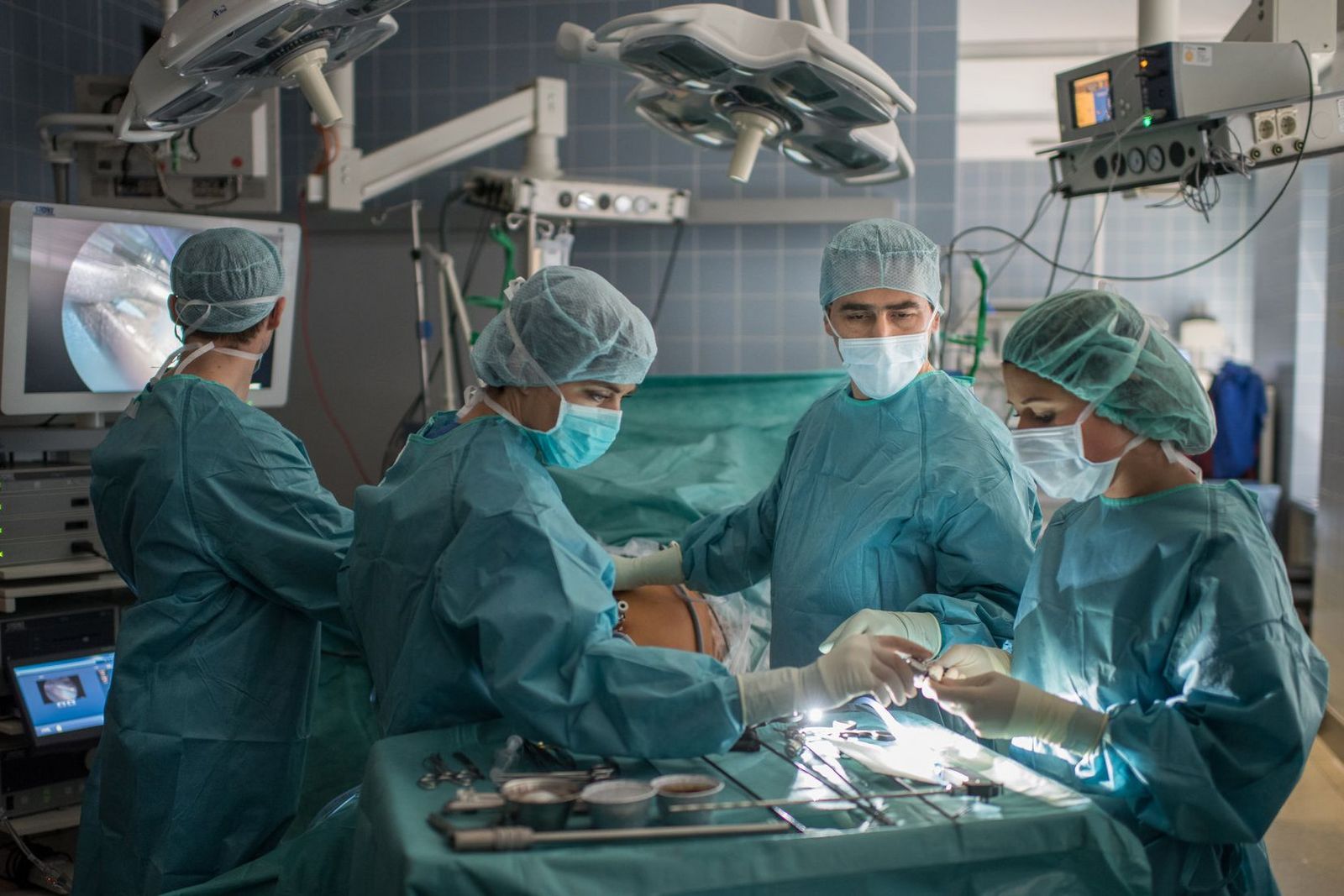 Ärztin und Ärzte im Operationssaal bei Gallenoperation mit miminal-invasiver Operationstechnik, das bedeutet operieren über kleinste Hautschnitte in den Körper
